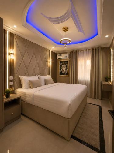 a bedroom with a large bed with a blue ceiling at Palazzo Apartments in Ikeja