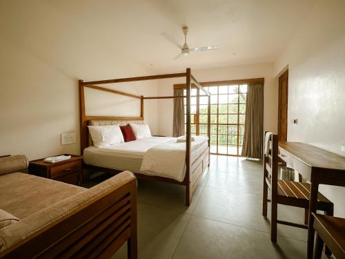 a hotel room with a bed and a desk and a bedsenalsenalsenalsenal at Serene Slopes in Vagamon
