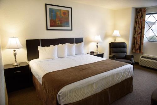 a hotel room with a large bed and a chair at Americas Best Value Inn New Paltz in New Paltz