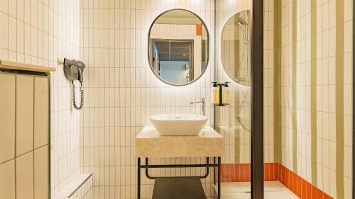 ein Badezimmer mit Waschbecken und Spiegel in der Unterkunft TULIP Hotels & Residences - Marne-la-Vallee Torcy in Torcy