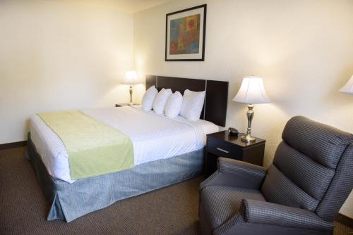 a hotel room with a bed and a chair at Americas Best Value Inn New Paltz in New Paltz