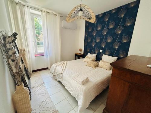 a bedroom with a bed with a blue wall at Gite d'Oliva in Suèvres