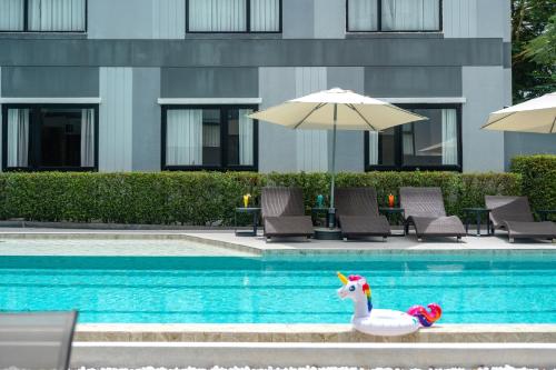 a toy unicorn sitting in a swimming pool at Gate43 Garden Villa in Lat Krabang