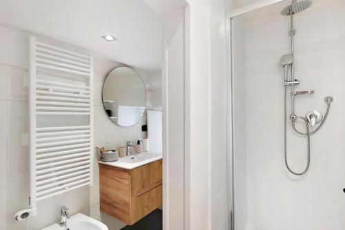 a white bathroom with a sink and a mirror at Aura Suites in Albenga