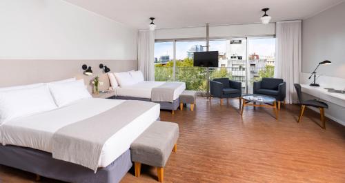 a hotel room with two beds and a balcony at Almarena Madero Urbano, Affiliated by Meliá in Buenos Aires