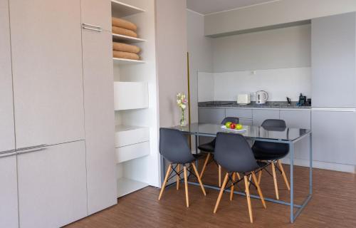 a kitchen with a table and four chairs at Almarena Madero Urbano, Affiliated by Meliá in Buenos Aires