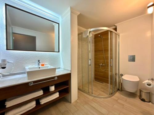 a bathroom with a sink and a shower at Altamare Hotel in Kuşadası