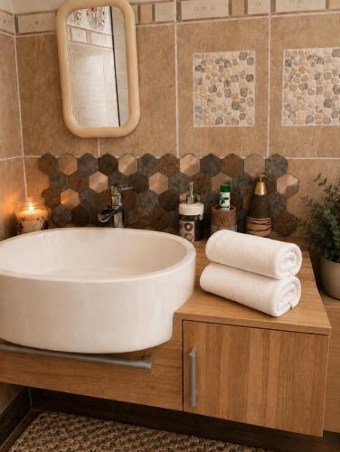 a bathroom with a tub and a mirror and towels at L'océane in Saint-Maurice-de-Beynost
