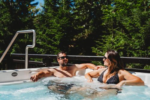 a man and woman sitting in a hot tub at Hotel Srdiečko in Tale