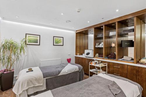 a bedroom with two beds and a tv in it at Keepers Cottage - Dartmouth Golf and Spa Resort in Dartmouth