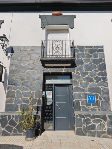 a building with a blue door and a balcony at Apartamentos La Bodega in La Zarza