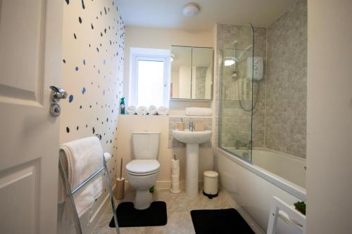 a bathroom with a toilet and a sink and a shower at Spacious Luxurious Serviced Accommodation 2 in Coventry
