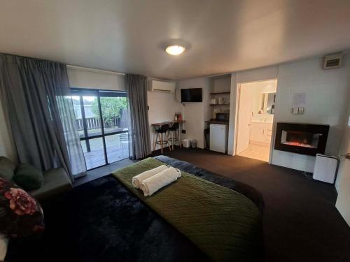 a bedroom with a bed and a living room with a fireplace at Mackenzie Motels in Fairlie