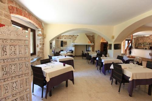 a restaurant with tables and chairs in a room at Nascar Hotel in Santa Maria Navarrese