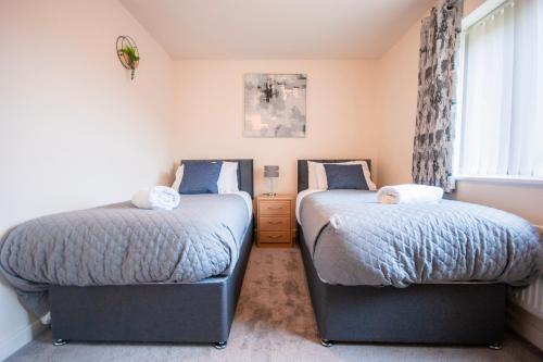 a bedroom with two beds and a window at Spacious Luxurious Serviced Accommodation 2 in Coventry