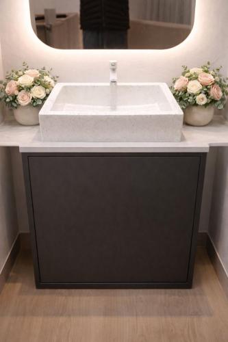 a bathroom with a white sink and a mirror at Oemah Ntuy Full view in Diyeng