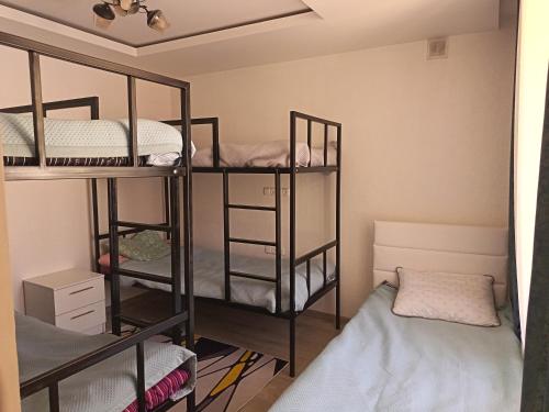 a room with three bunk beds in a room at Nanik Hostel in Khorog