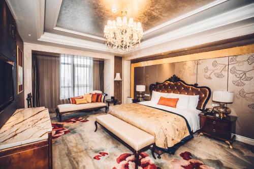 a bedroom with a large bed and a chandelier at Wanda Realm Dandong in Dandong