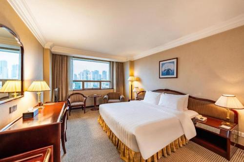 a hotel room with a bed and a desk at Kunming Hotel in Kunming