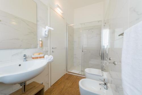 a white bathroom with a sink and a shower at Caladune Resort in Pizzo