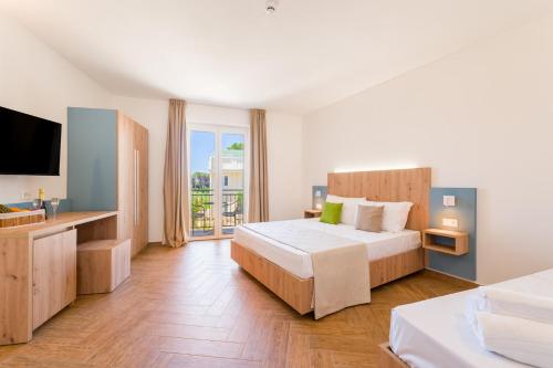 a hotel room with a bed and a television at Caladune Resort in Pizzo