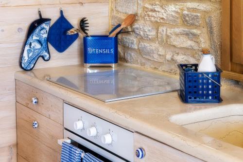 a kitchen counter with a sink and a stone wall at Nous Village 2 in Alyki