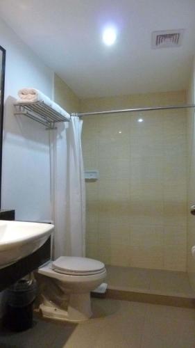 a bathroom with a shower and a toilet and a sink at Circle Inn - Iloilo City Center in Iloilo City