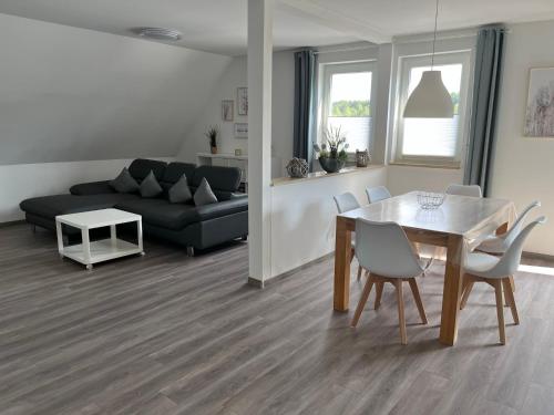 a living room with a table and a couch at Ferienwohnung Schöpf - Fränkische Schweiz in Obertrubach