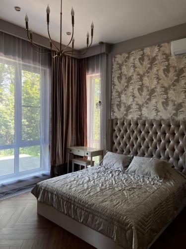 a bedroom with a large bed and a large window at LouLou Hills in Uchastkovoyye Khozyaystvo SKhI