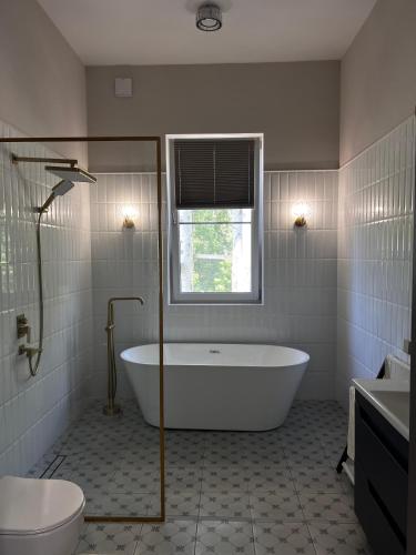 a white bathroom with a tub and a window at LouLou Hills in Uchastkovoyye Khozyaystvo SKhI