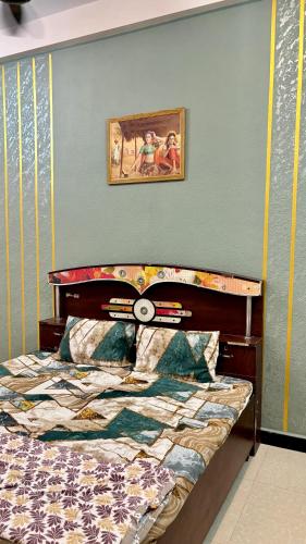 a bedroom with a bed and a picture on the wall at Next Home Stay in Nalkhera