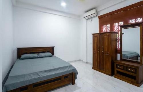 a bedroom with a bed and a dresser and a mirror at The Ivy Grove in Mahabage