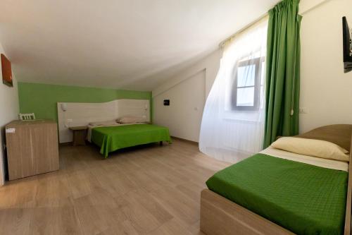 a room with two beds and a green curtain at La Duchessa e Il Contadino in Vieste
