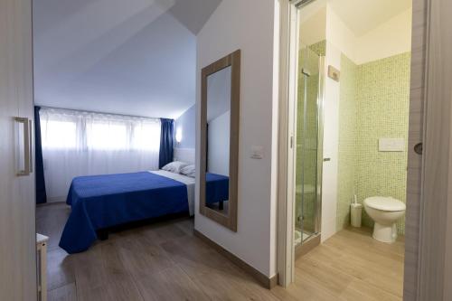 a bedroom with a bed and a bathroom with a toilet at La Duchessa e Il Contadino in Vieste