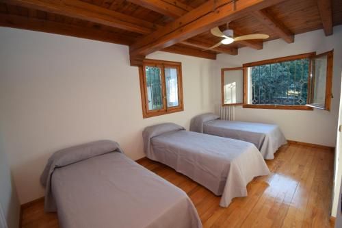 a room with two beds and two windows at La Casona Imperial 2 in Galapagar