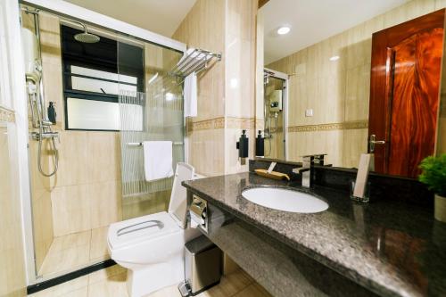 a bathroom with a toilet and a sink at Highlands Suites Hotel and Apartments in Kigali