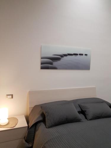 a bedroom with a bed with a picture on the wall at Casa vacanza Furlani in Grottaferrata