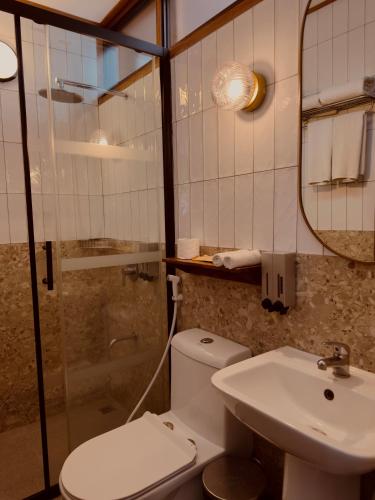 a bathroom with a toilet and a sink and a mirror at The Lark Inn & Kitchen in San Juan