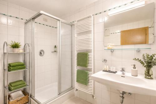 a white bathroom with a shower and a sink at Residence Bondì in Colfosco