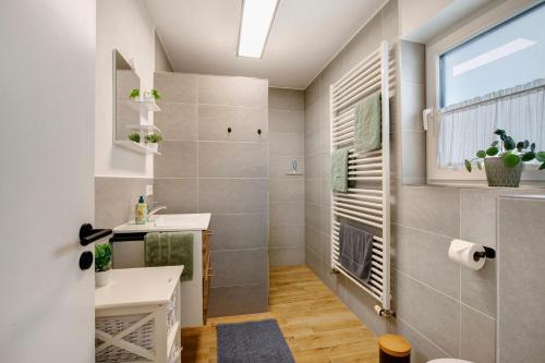 a bathroom with a sink and a toilet and a window at Ferienwohnung am Alenberg in Münsingen