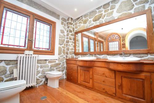 a stone bathroom with a sink and a mirror at La Casona Imperial 2 in Galapagar