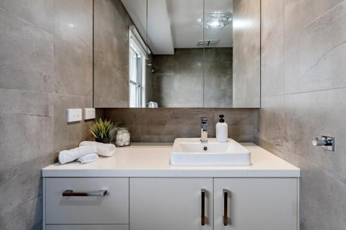 a bathroom with a white sink and a mirror at Ocean Grove Beach House 2 - Pets - Late checkout - Accessible in Ocean Grove