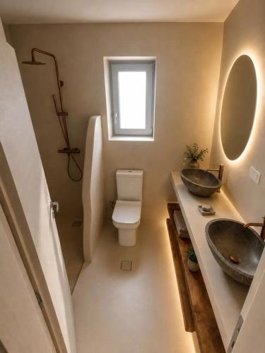 a bathroom with two sinks and a toilet at Doto Villa with private pool in Agia Effimia
