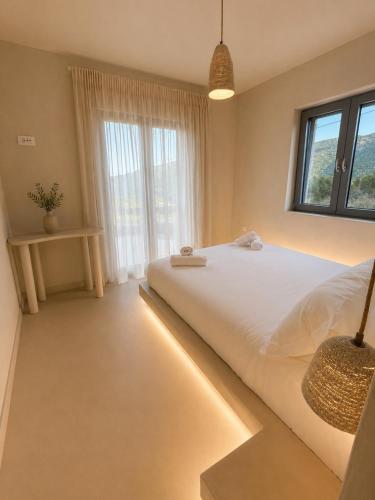 a bedroom with a large bed with lights on it at Doto Villa with private pool in Agia Effimia