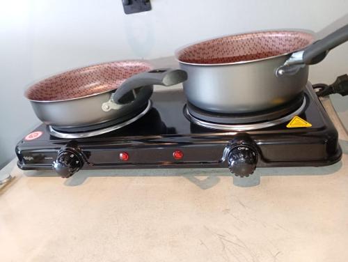 two pots sitting on top of a stove at Bugan Premium 16 andar - vista mar incrível in Recife