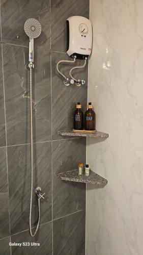 a shower with two shelves in a bathroom at Chaya village F shared pool jacuzzi in Phra Ae beach