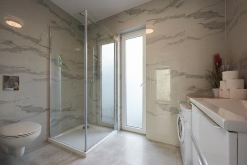 a bathroom with a shower and a toilet and a sink at Domki Beztroska Białogóra in Białogóra