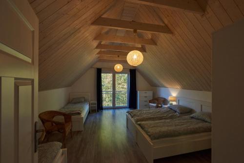 a bedroom with two beds and a ceiling with wood at Domki Beztroska Białogóra in Białogóra