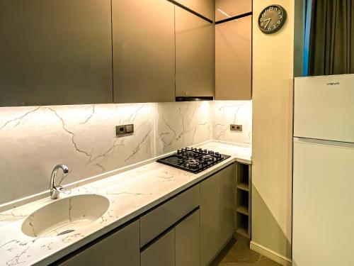 a kitchen with a sink and a stove and a refrigerator at Hotel Nika in Batumi