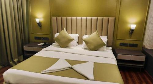 a bedroom with a large white bed with two tables at Sun City Resort in Calangute